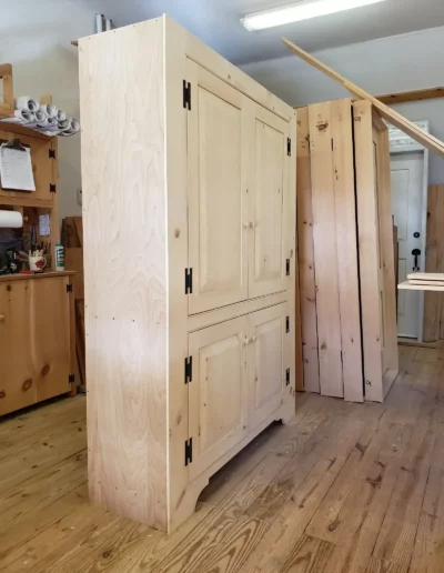 Image of an unfinished Media Cabinet and Pre-Hung Doors in the workshop at Early New England Homes