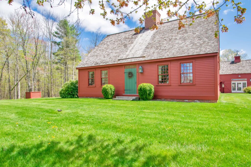 Exterior photo of the red Cape model at Early New England Homes in Bolton, Connecticut