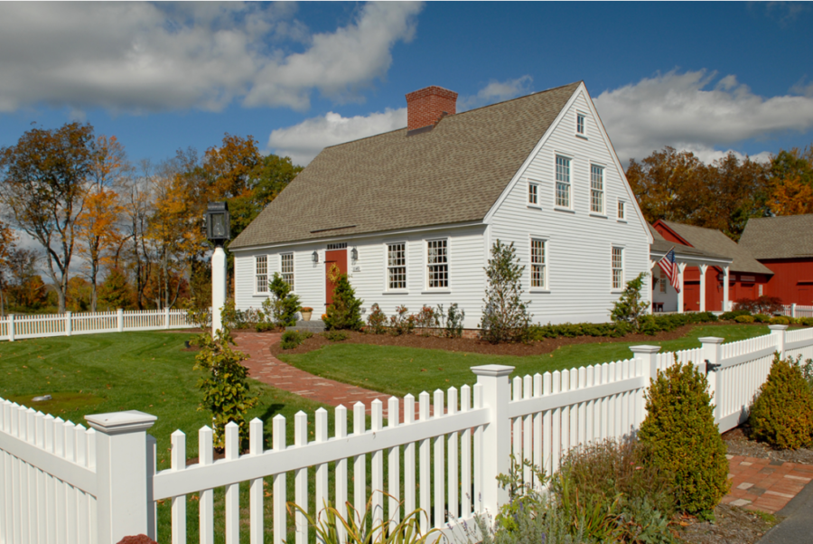 White Cape Cod house with a white fence